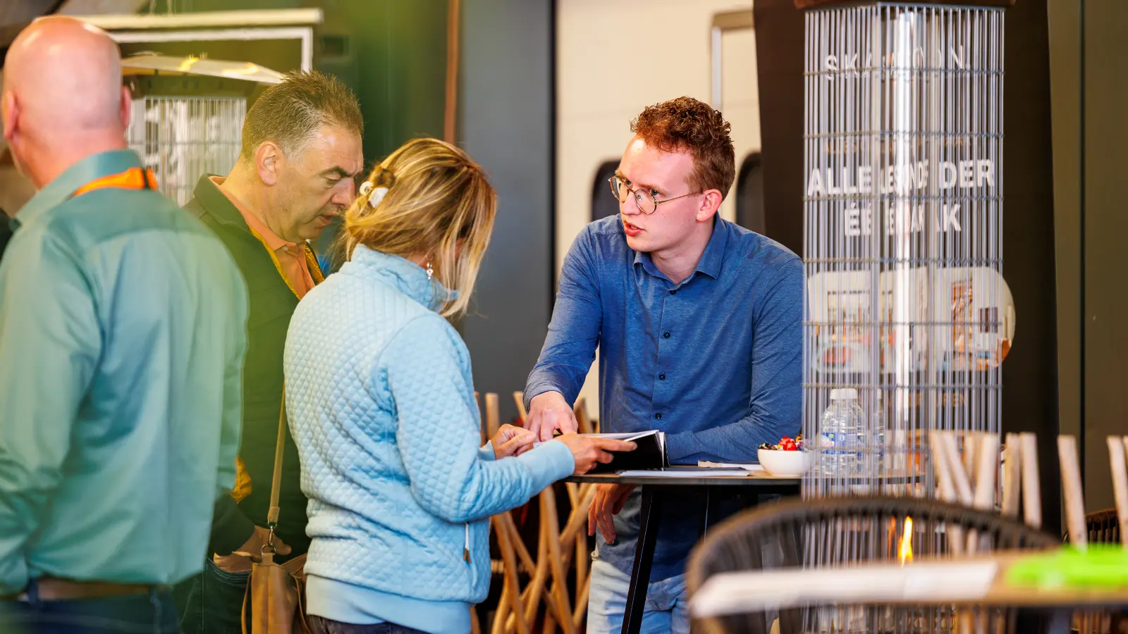 Twee mensen in gesprek bij een statafel