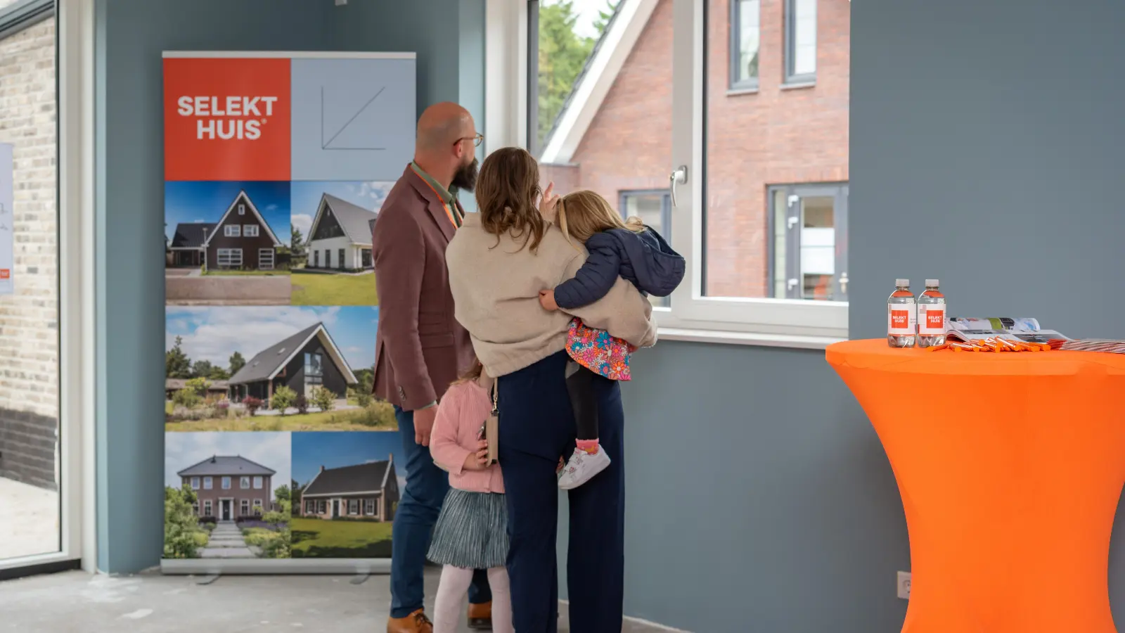 Ouders met kinderen kijken uit het raam