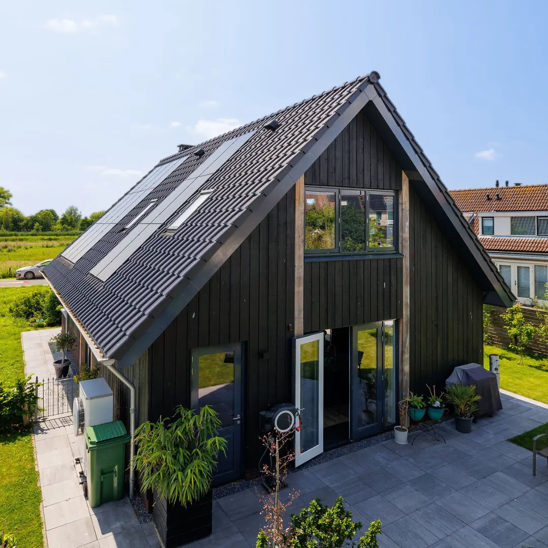 Zwarte schuurwoning met eiken balken en zwarte planken