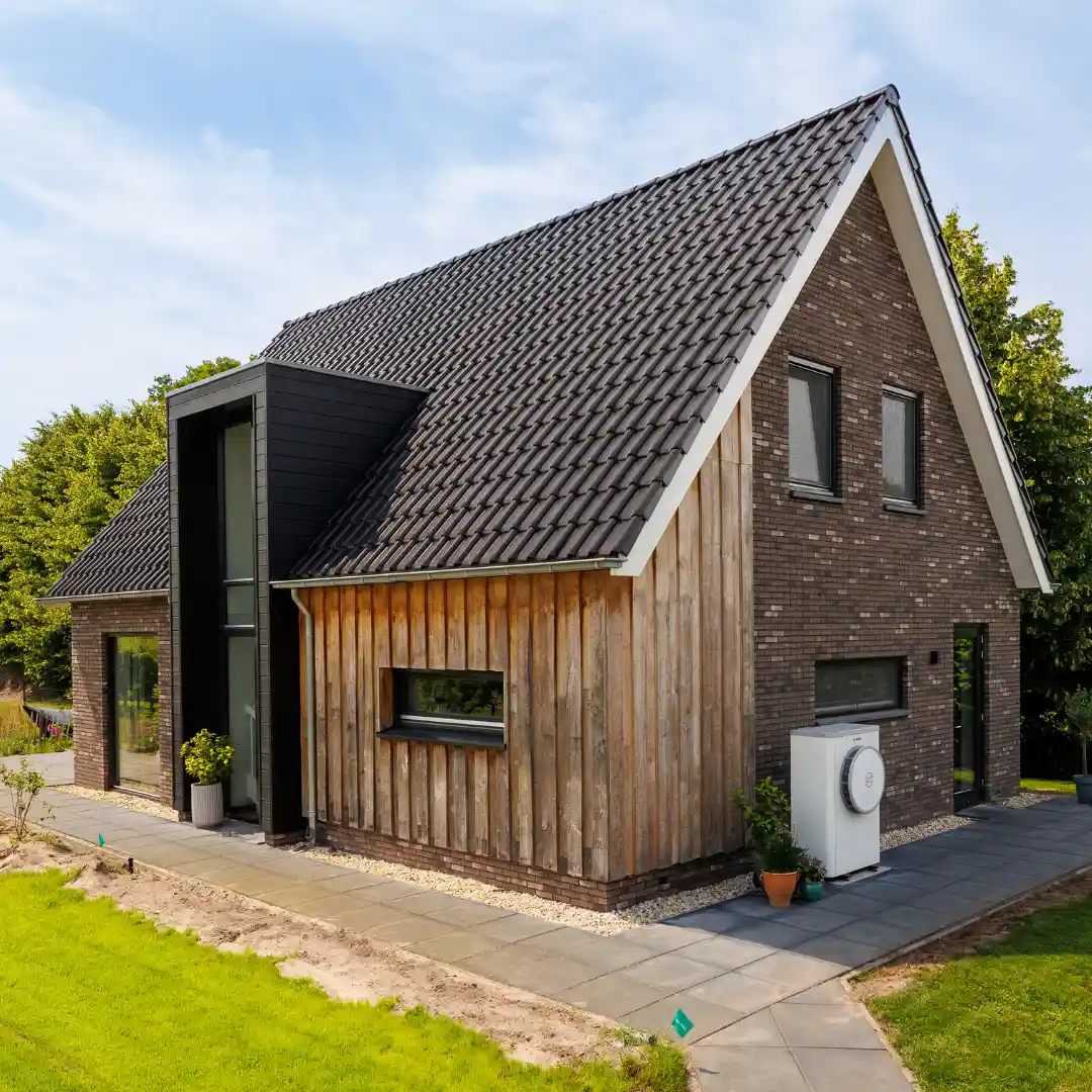 Zijaanzicht moderne landelijk gezinswoning met risaliet en houten gevelbekleding