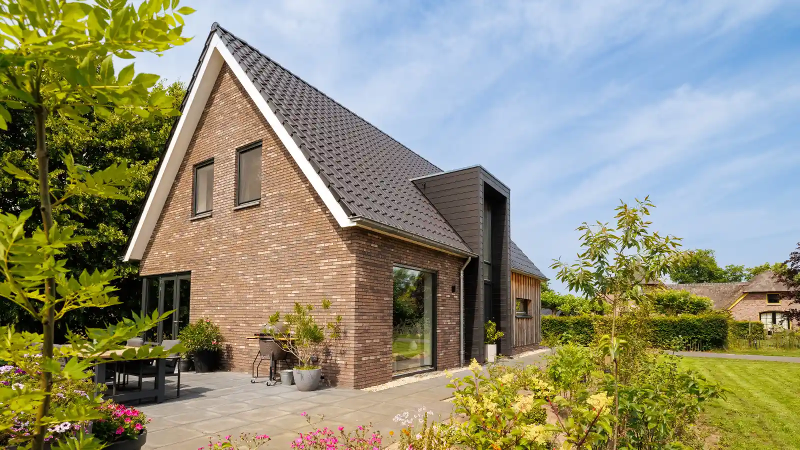 Zijaanzicht moderne landelijk gezinswoning met risaliet en houten gevelbekleding