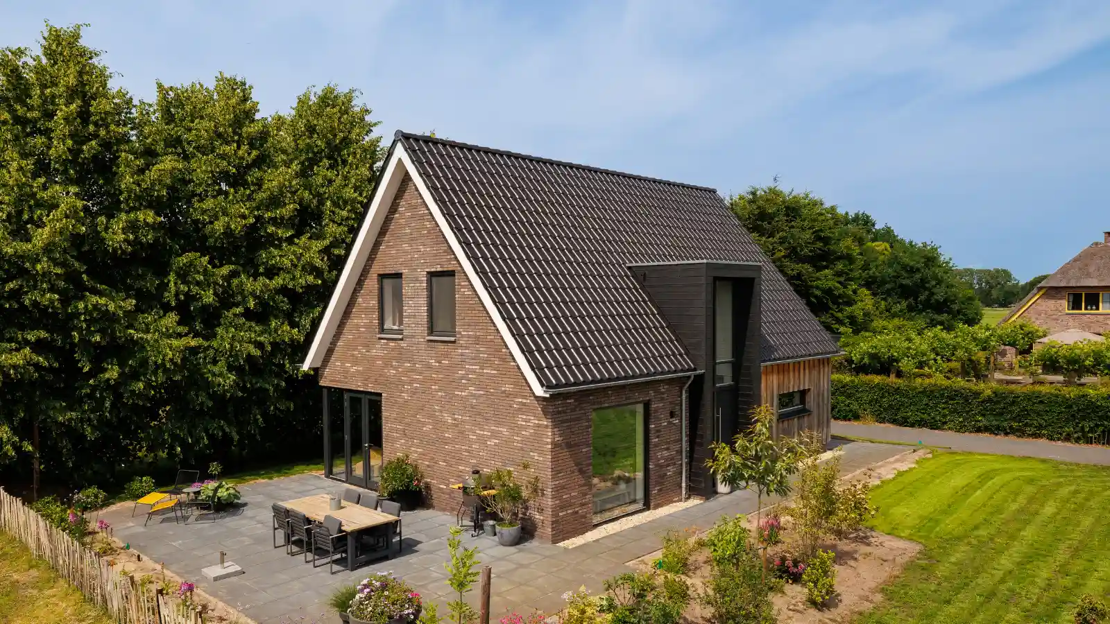 Zijaanzicht moderne landelijk gezinswoning met risaliet en houten gevelbekleding