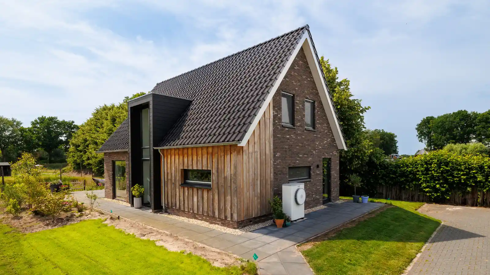 Zijaanzicht moderne landelijk gezinswoning met risaliet en houten gevelbekleding