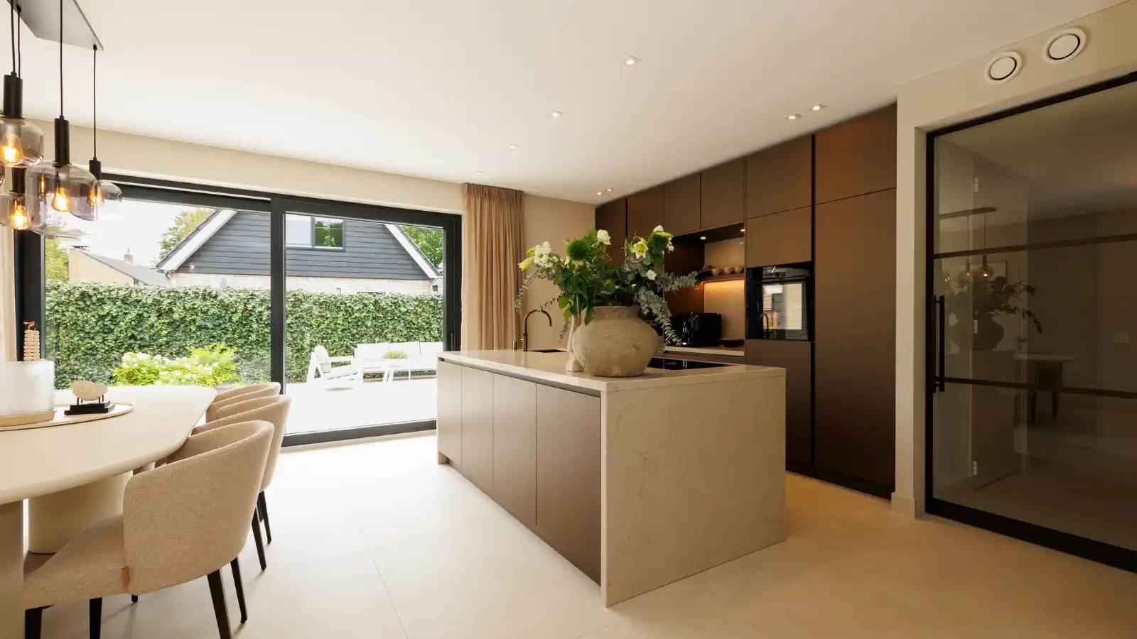 Open keuken met kookeiland en eettafel met stoelen