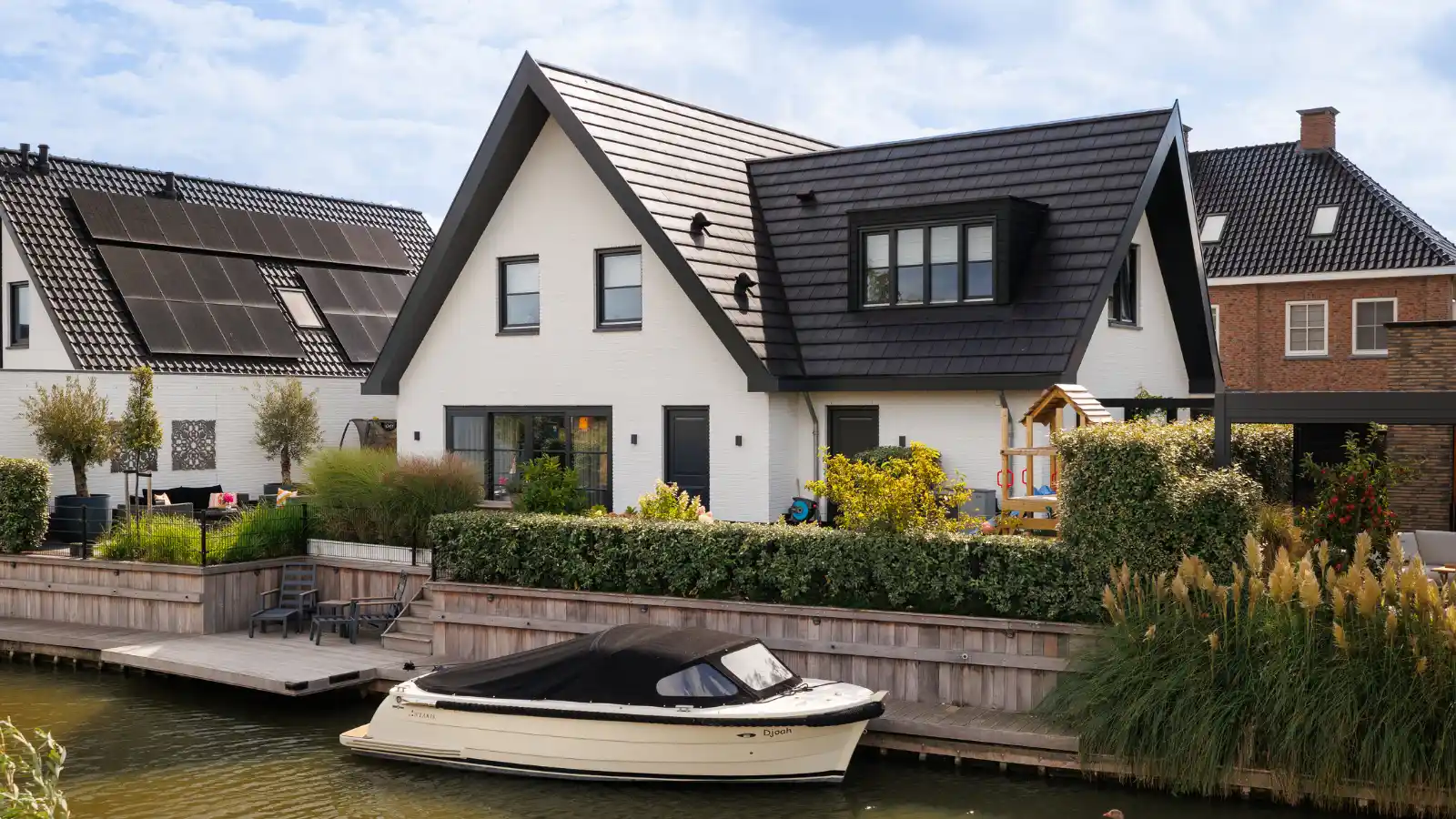 Vrijstaande woning met rieten dak en aanbouw. Liggend aan het water