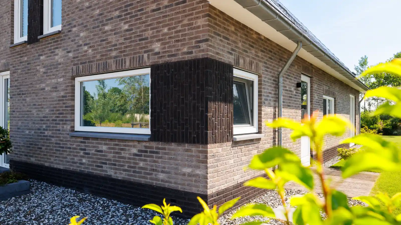 Hoek van vrijstaande woning met donkere rechtopstaande stenen