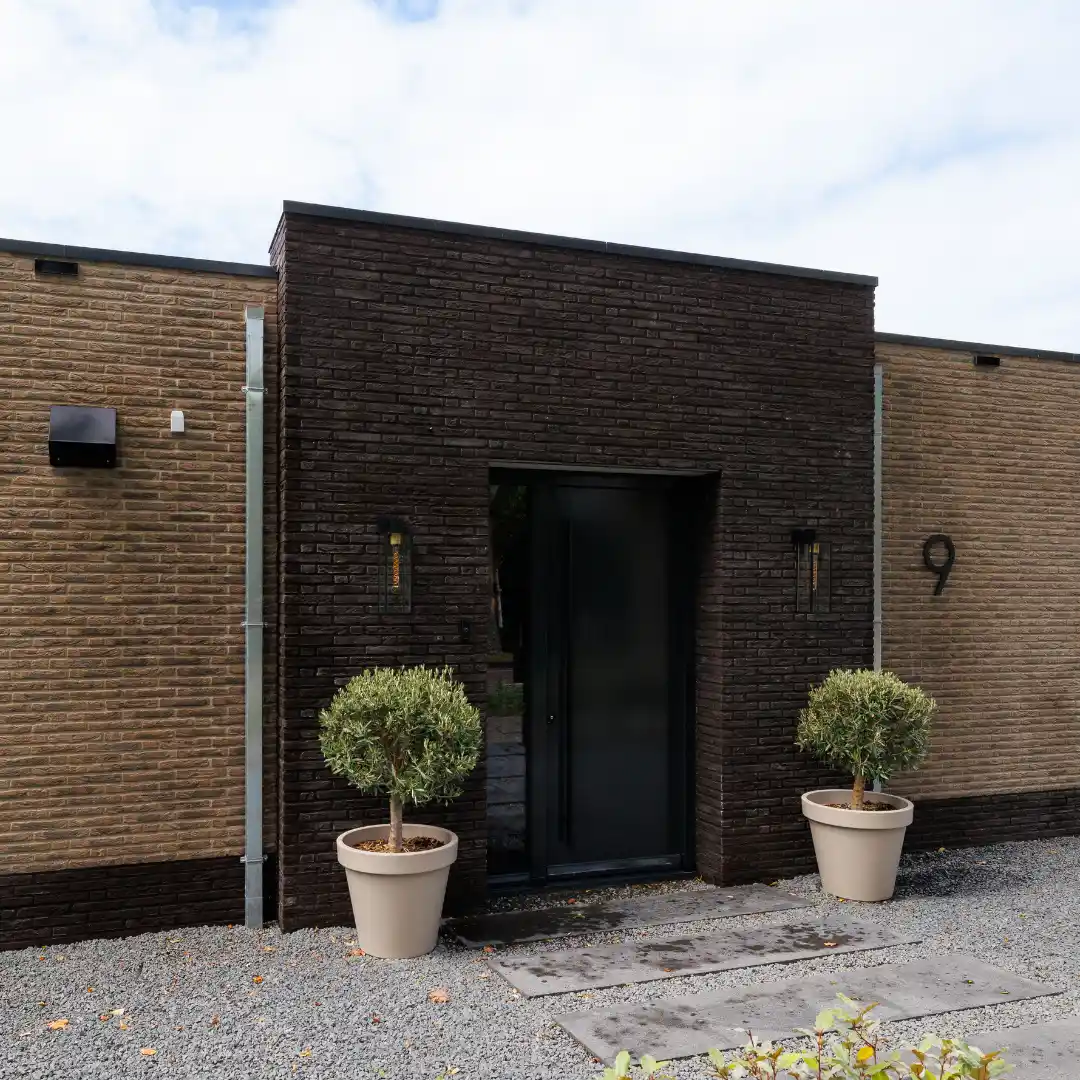 Voordeur omlijst met donkere bakstenen
