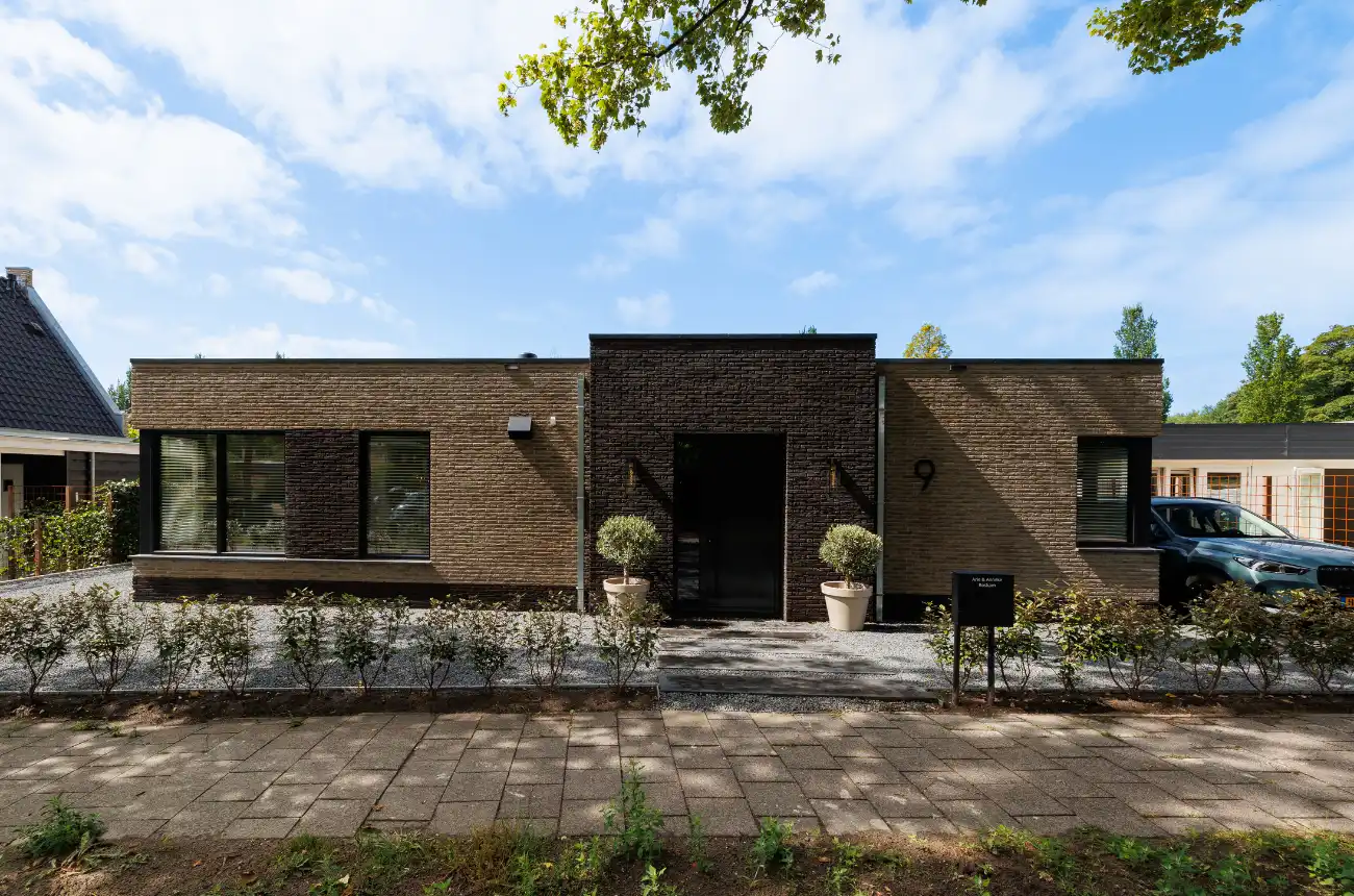 Vooraanzicht bungalow met donkere stenen rondom de voordeur