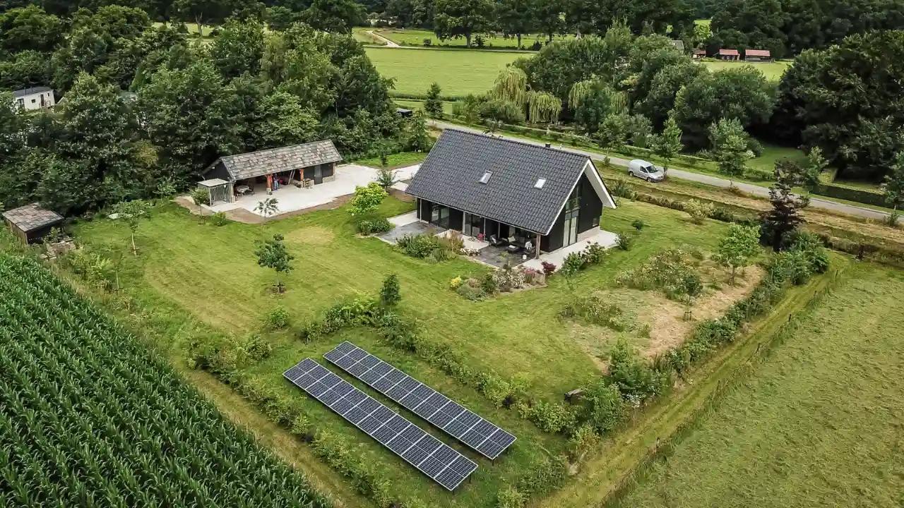 Vrijstaande schuurwoning op een groot perceel met zonnepanelen op het gras