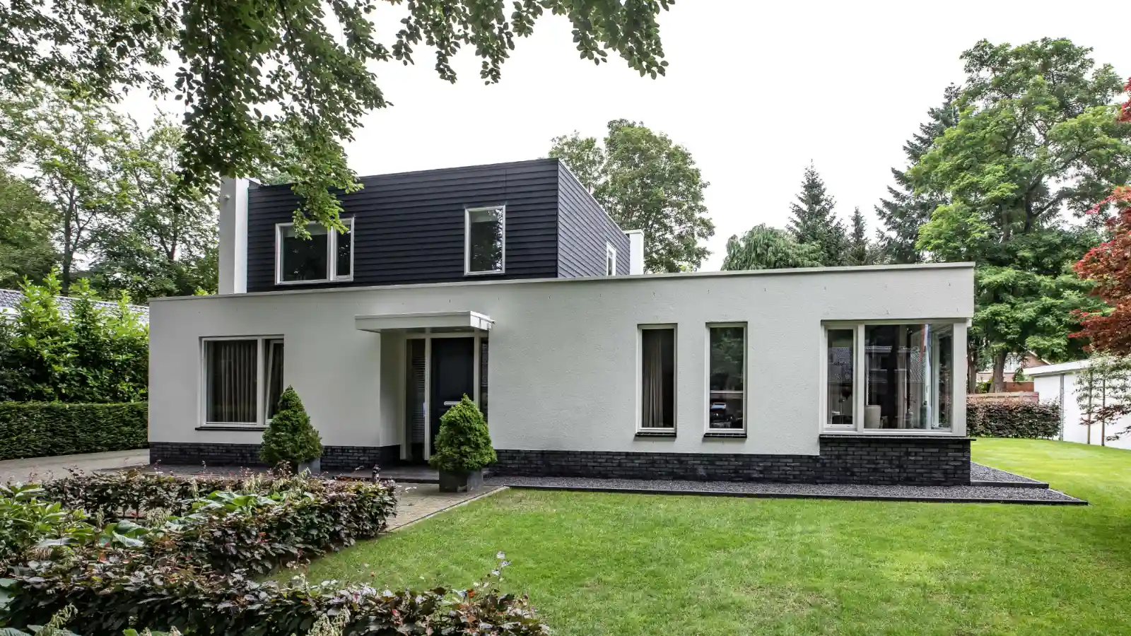 Witte vrijstaande bungalow met opbouw van houtengevelbekleding