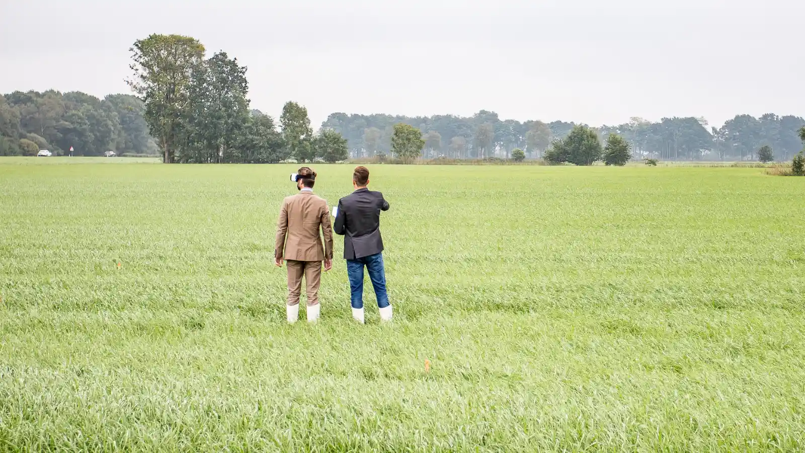 Twee mannen staan in een groen grasveld