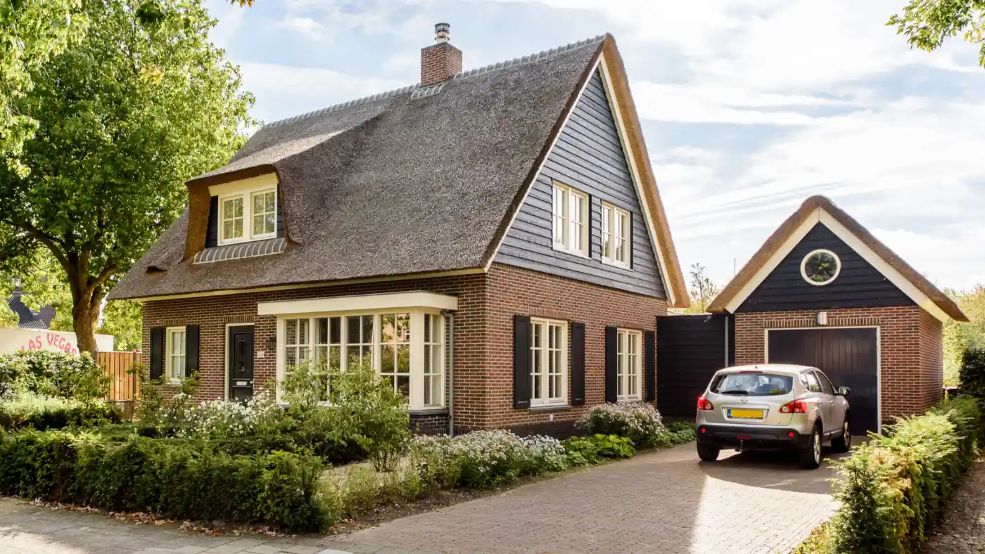 Vrijstaande woning met rode gevelbekleding en rieten kap