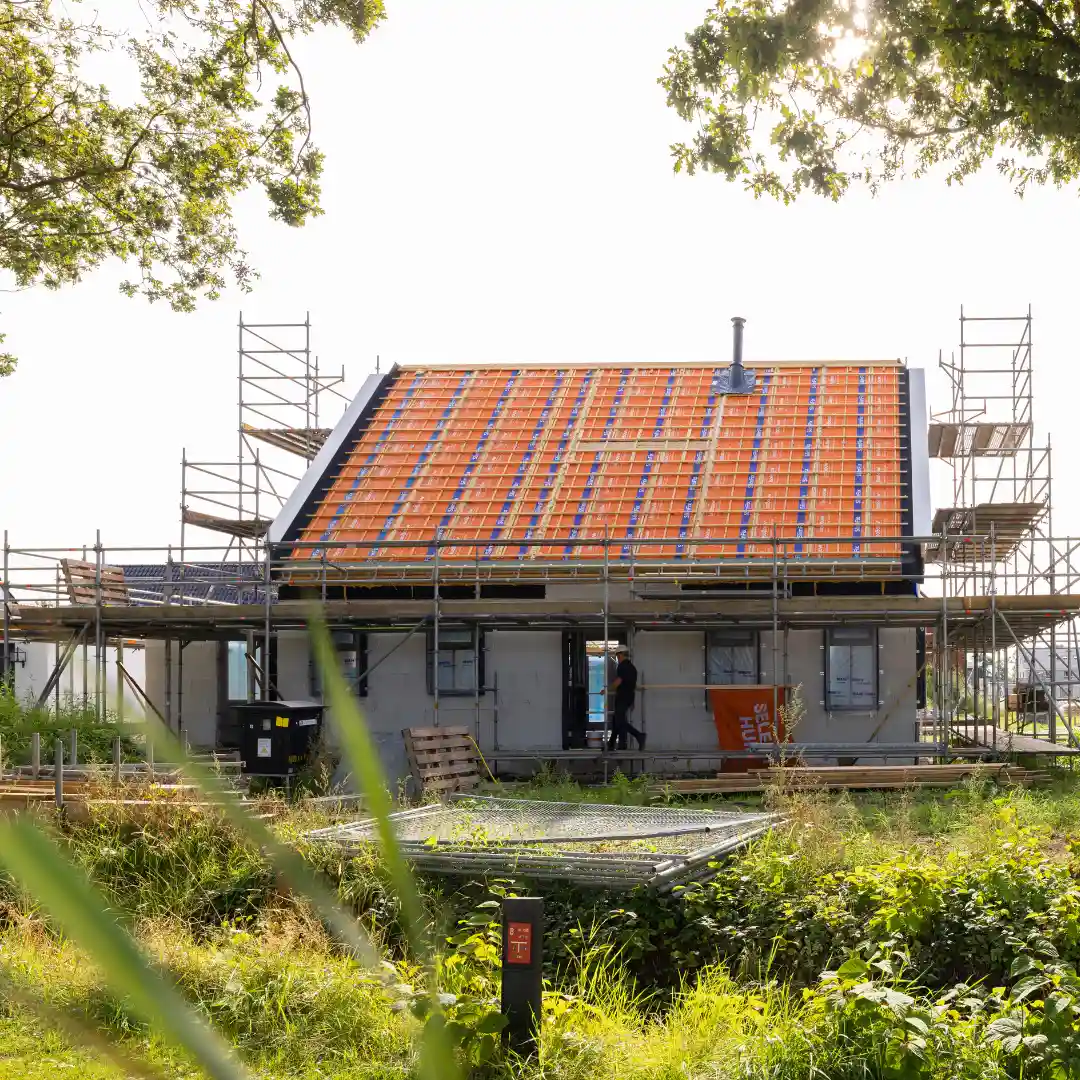 Vrijstaande woning in aanbouw met steigers om de woning