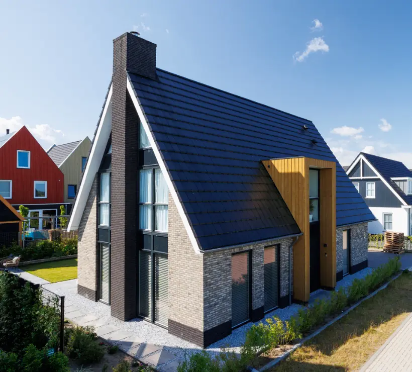 Zijaanzicht van vrijstaande woning met houten risaliet