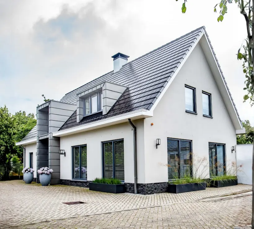 Vooraanzicht van een eigentijdse vrijstaande woning met wit gevelsauswerk