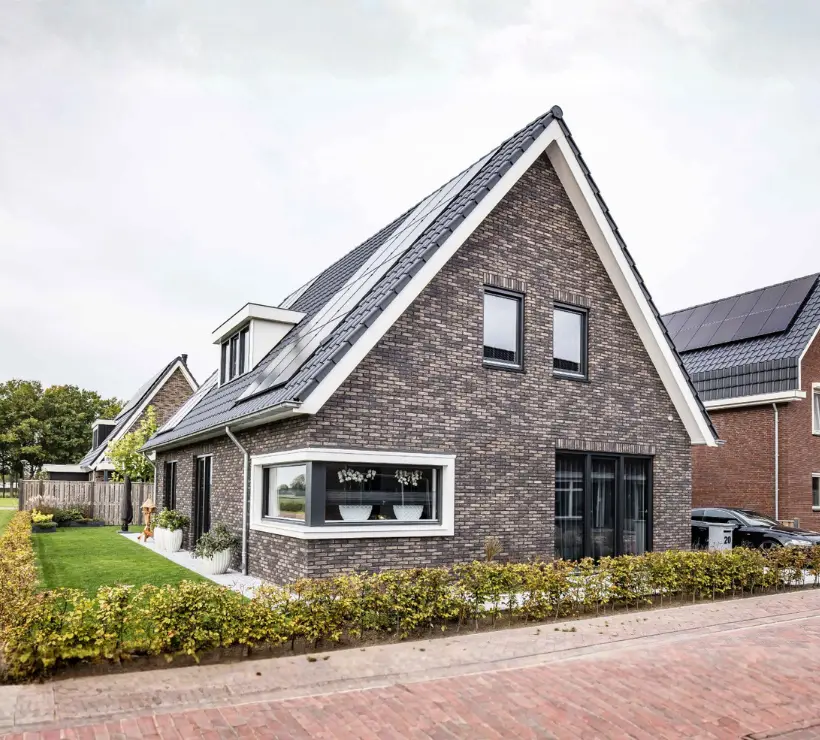 Vooraanzicht van een eigentijdse woning met donkere gevelstenen