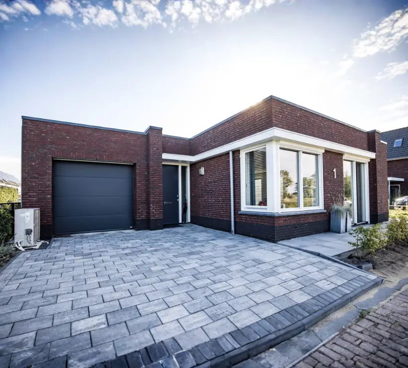 Vooraanzicht van een vrijstaande woning met jaren '30 bouwstijl en plat dak