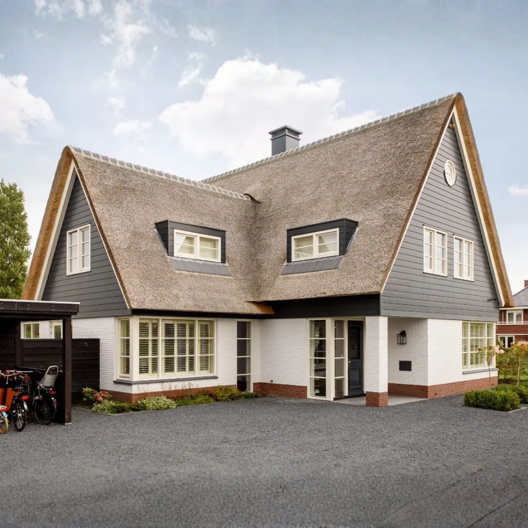  Landelijke vrijstaande woning met rieten dak en wit gevelsauswerk