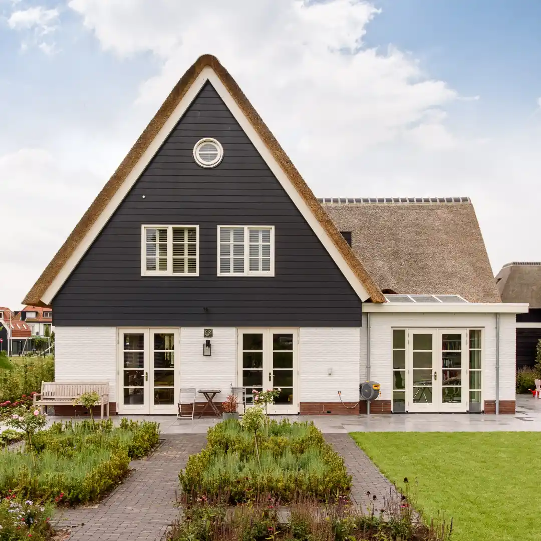 Achteraanzicht van een landelijke woning met rieten dak