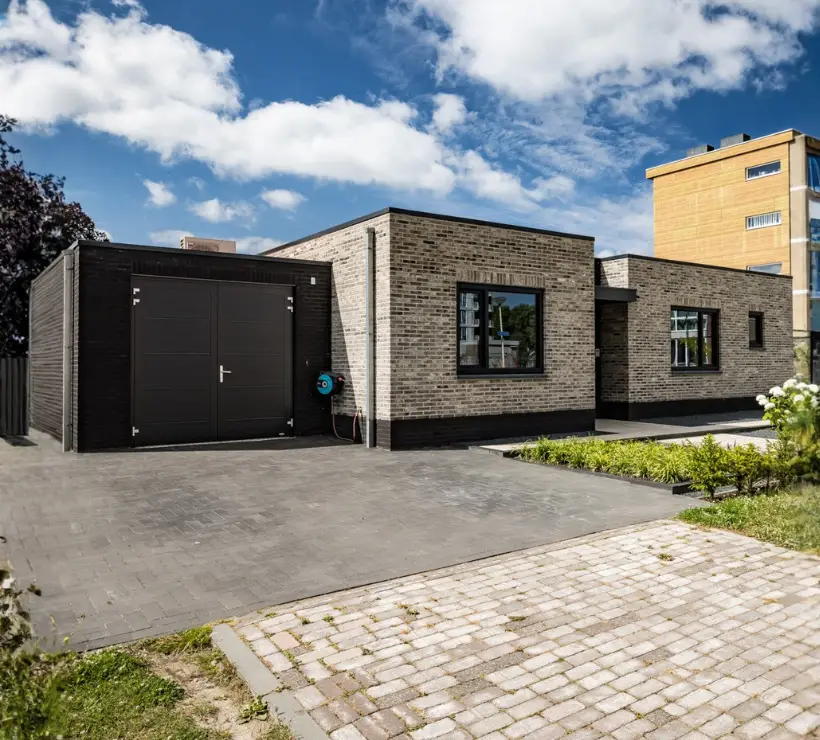 Vooraanzicht van een woning met plat dak en aanbouw