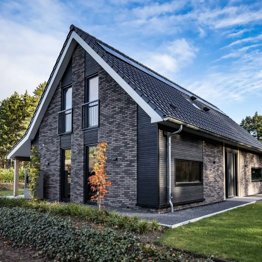 Vooraanzicht van een vrijstaande schuurwoning met houten gevelbekleding