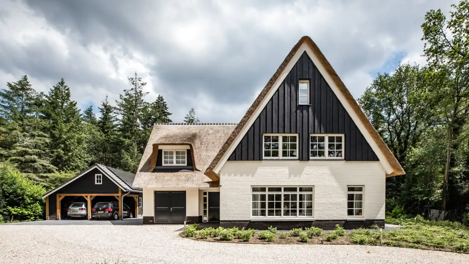 Vooraanzicht van een wit landhuis met rieten kap