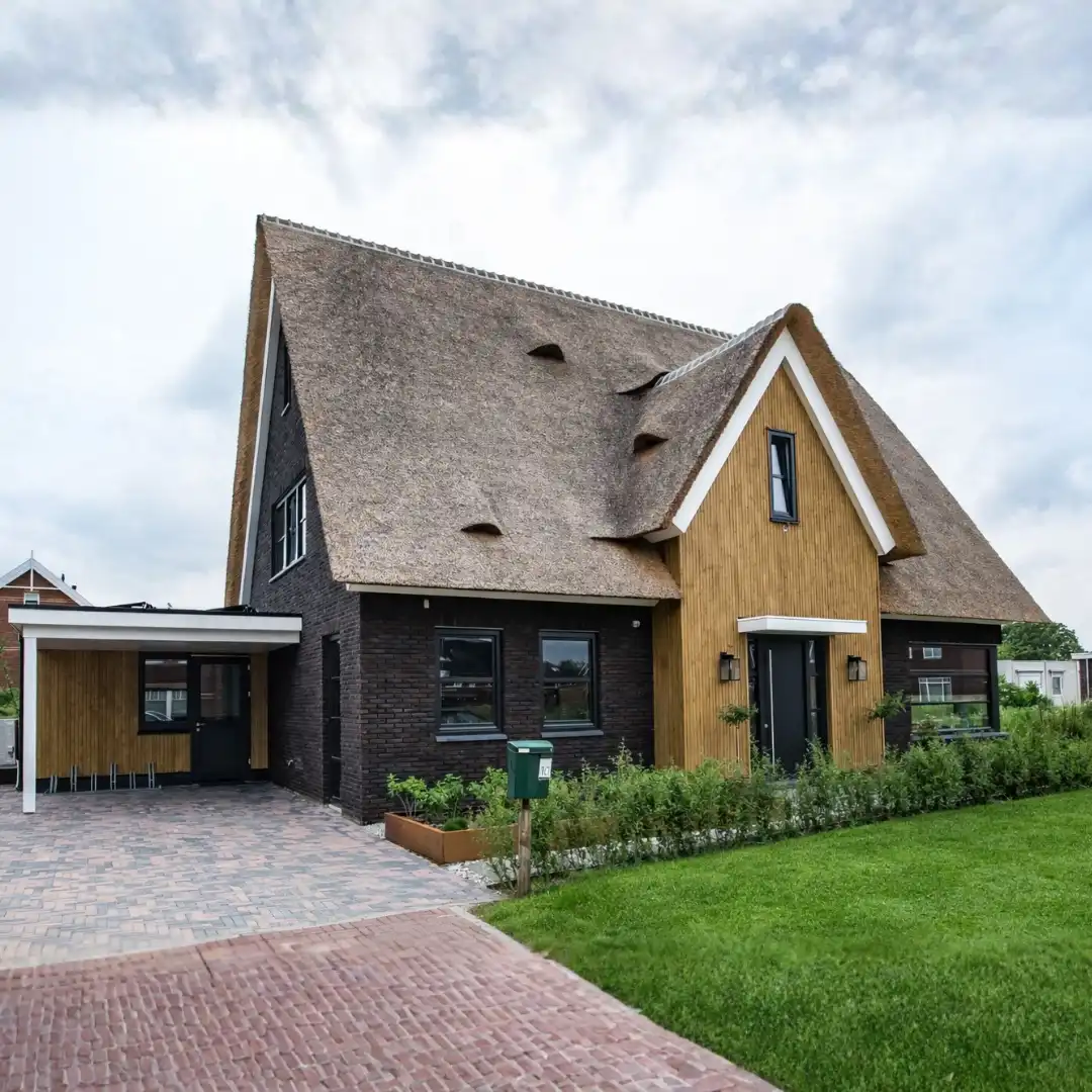 Moderne vrijstaande woning met rieten kap en houten gevelbekleding
