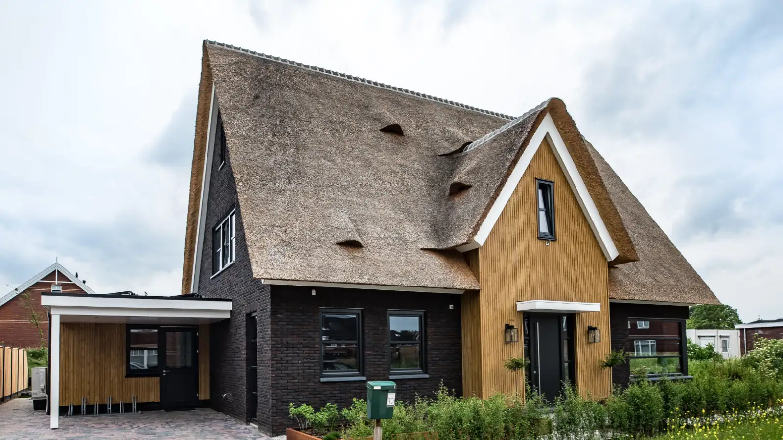 Moderne vrijstaande woning met rieten kap en houten gevelbekleding