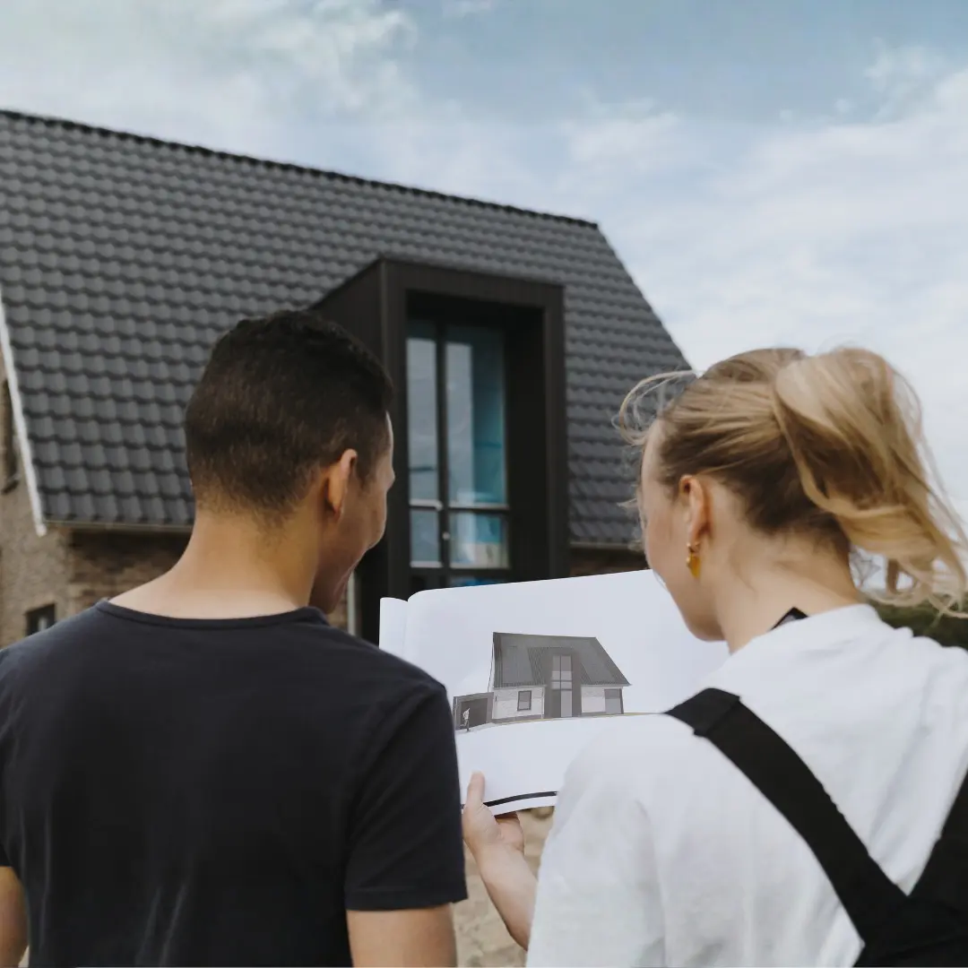Man en vrouw kijken naar een render van hun woning met de woning op de achergrond