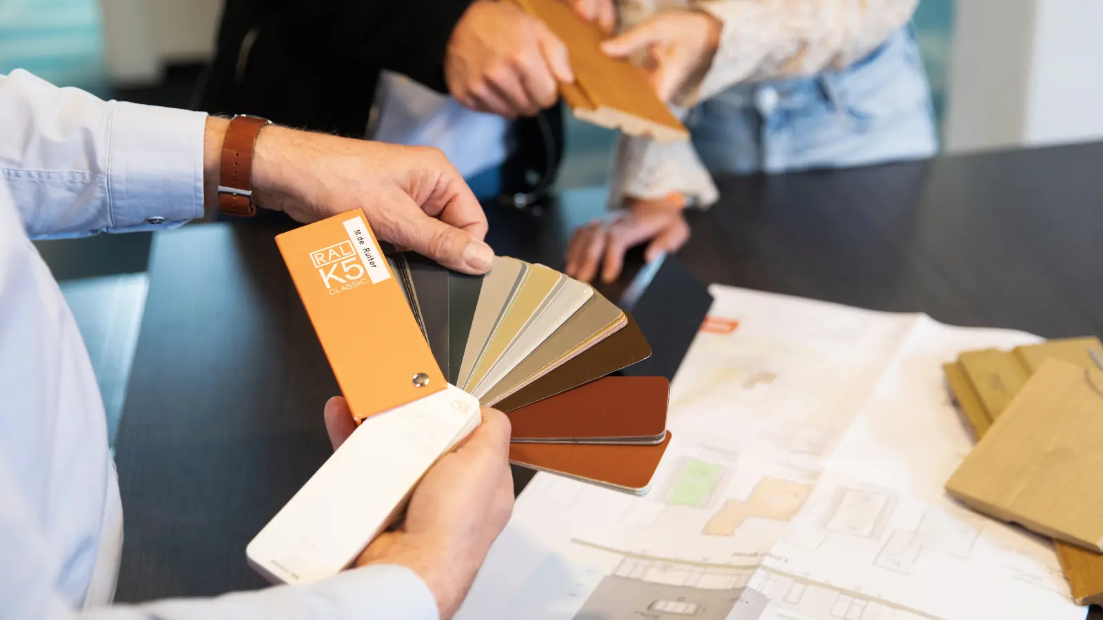 advisuer heeft een een staaltje met verschillende kleuren in de hand
