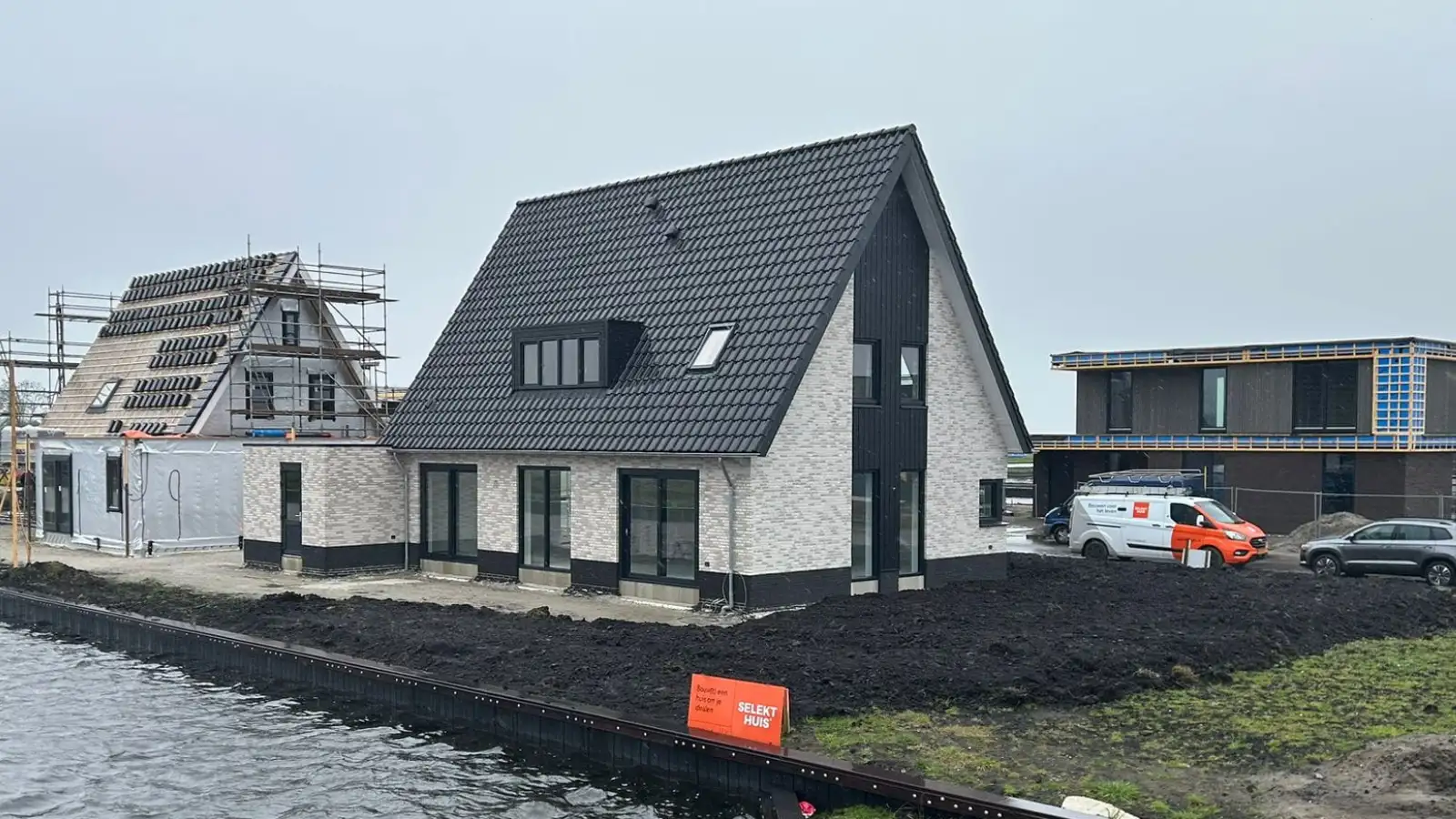 Vrijstaande woning met licht grijze gevelstenen en zwart houtengevelbekleding