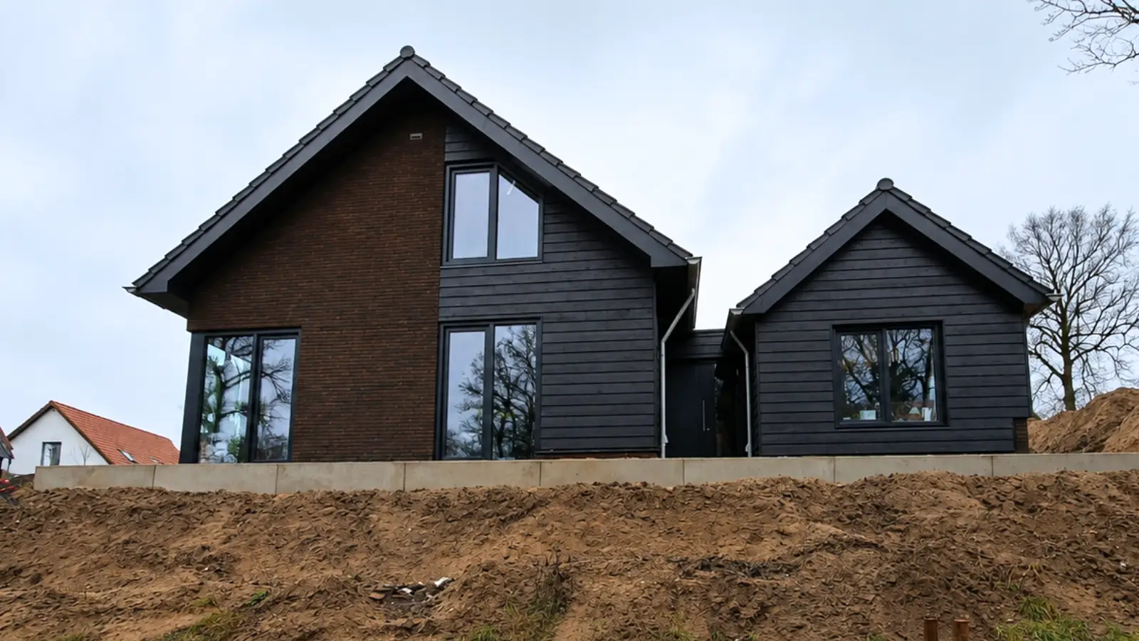 Vrijstaande woning met donkere stenen en zwart houtengevelbekleding