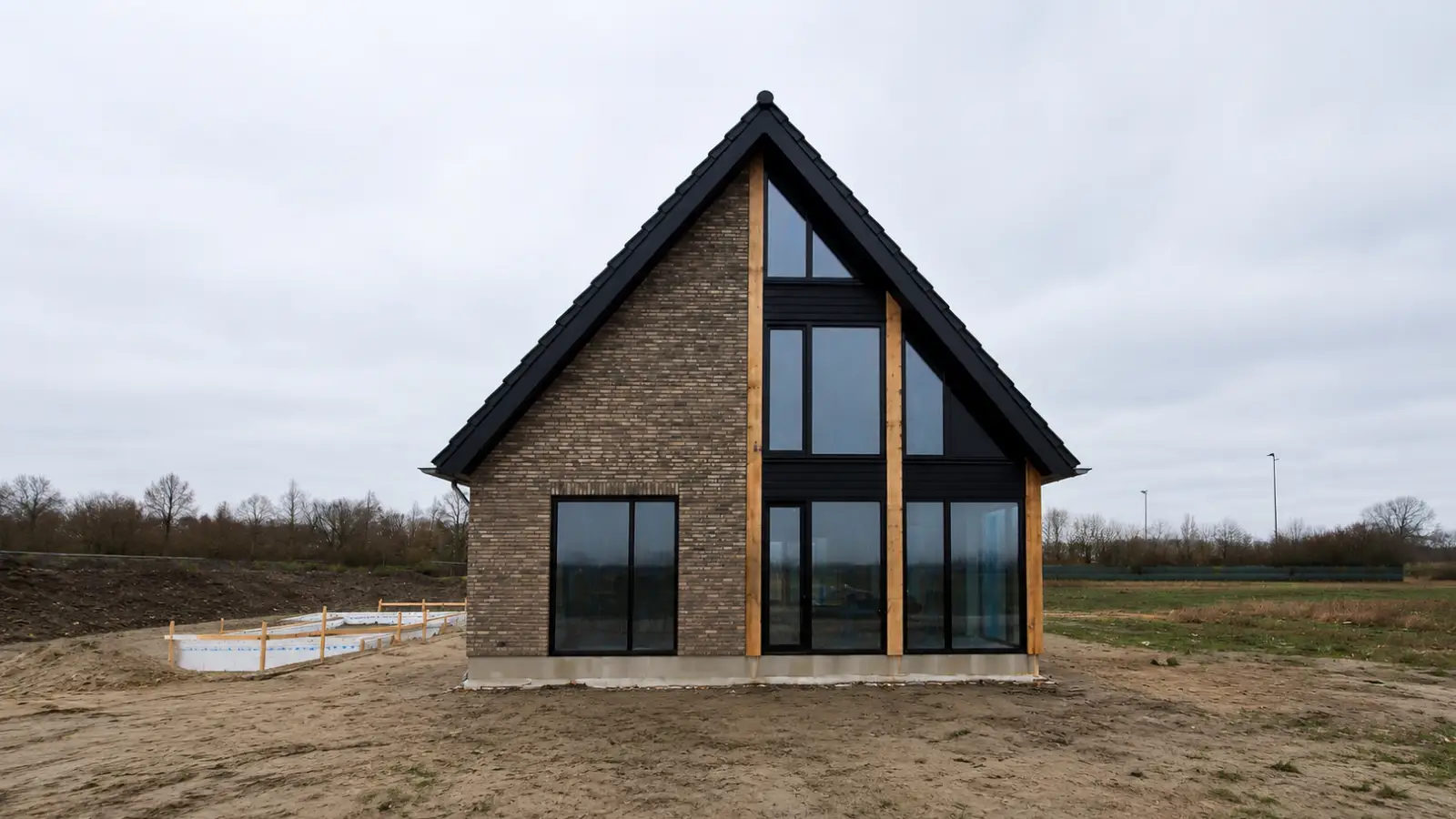 vrijstaande woning met veel glas en houten balken in de gevel