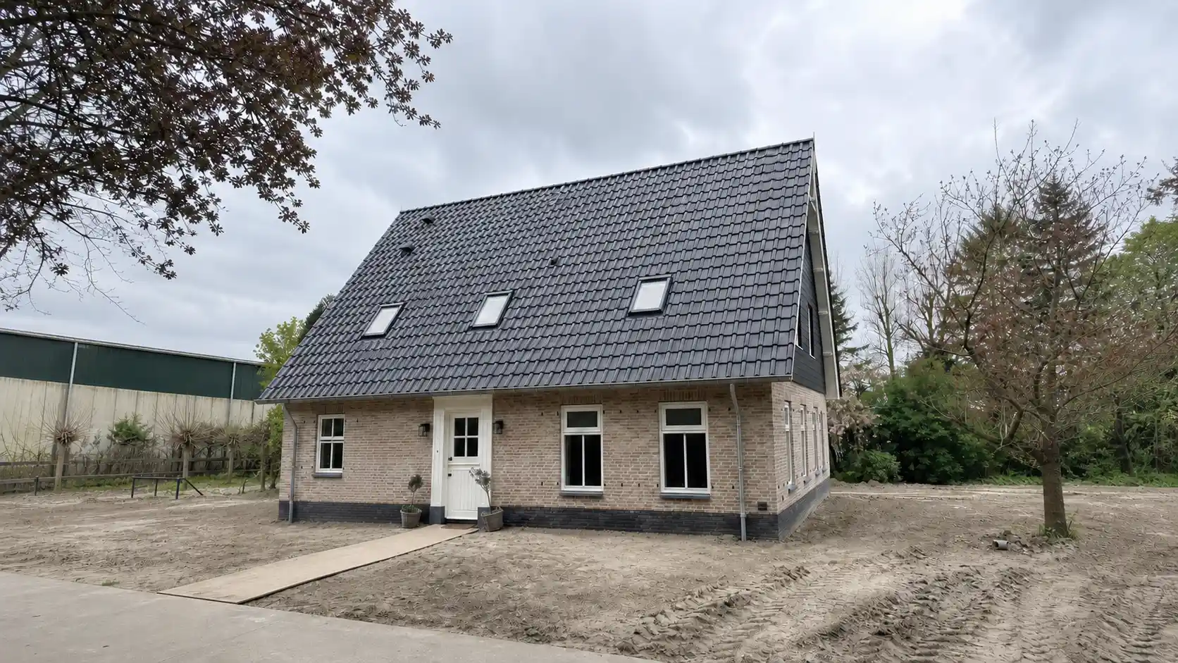 Vrijstaande woningen met lichte gevelstenen en zwarte gevelbekleding