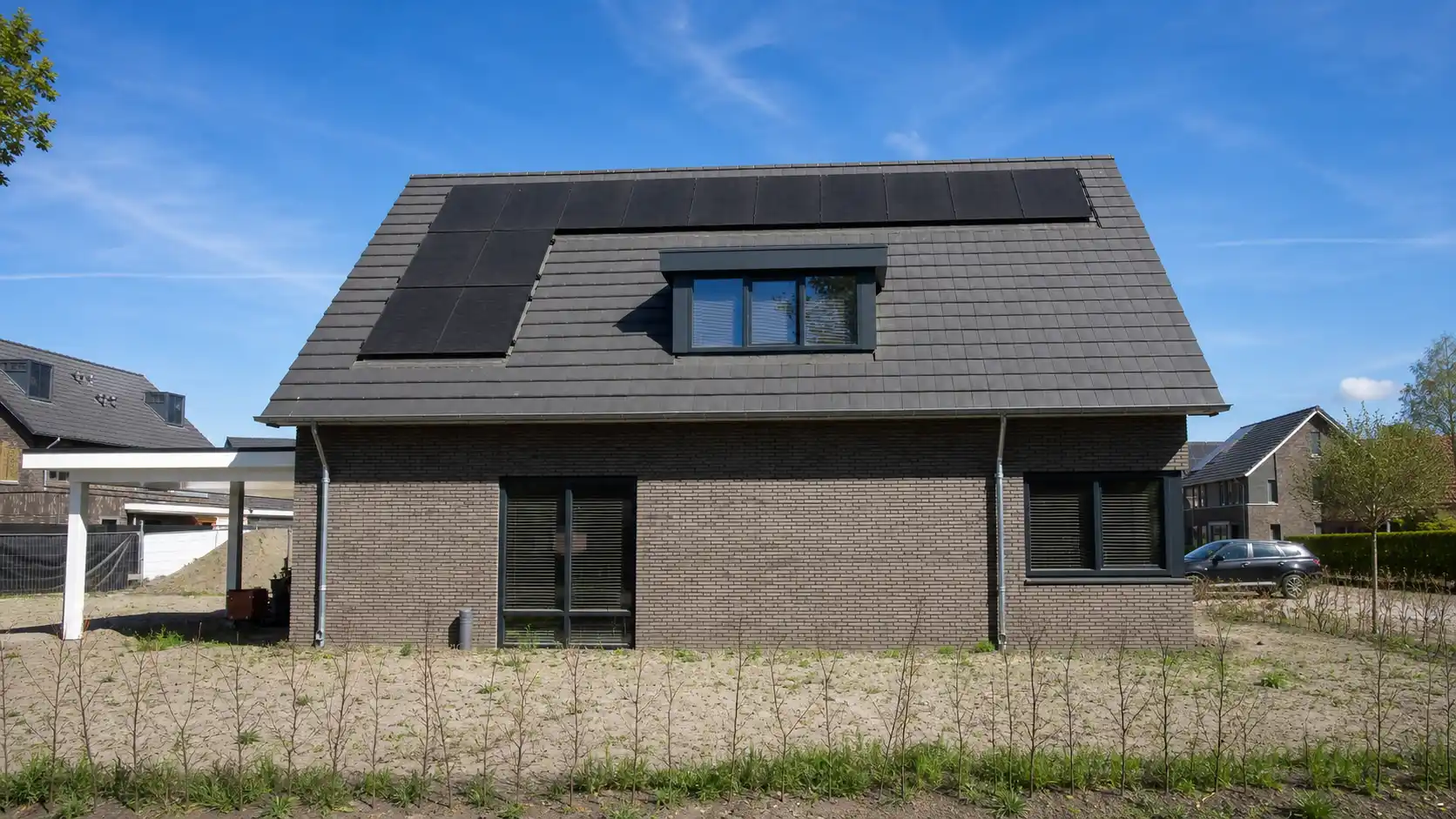 Vrijstaande woning met donkere gevelstenen en dakkapel