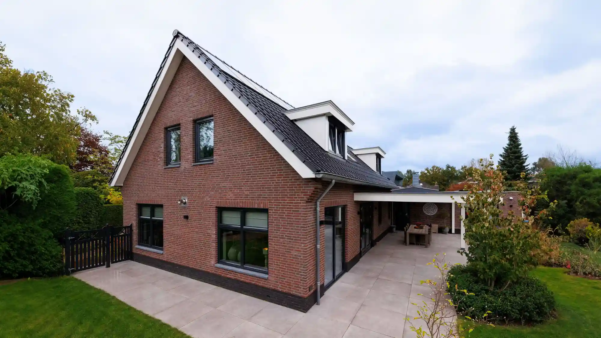 Vrijstaande woning met rode gevelstenen en dakkapel