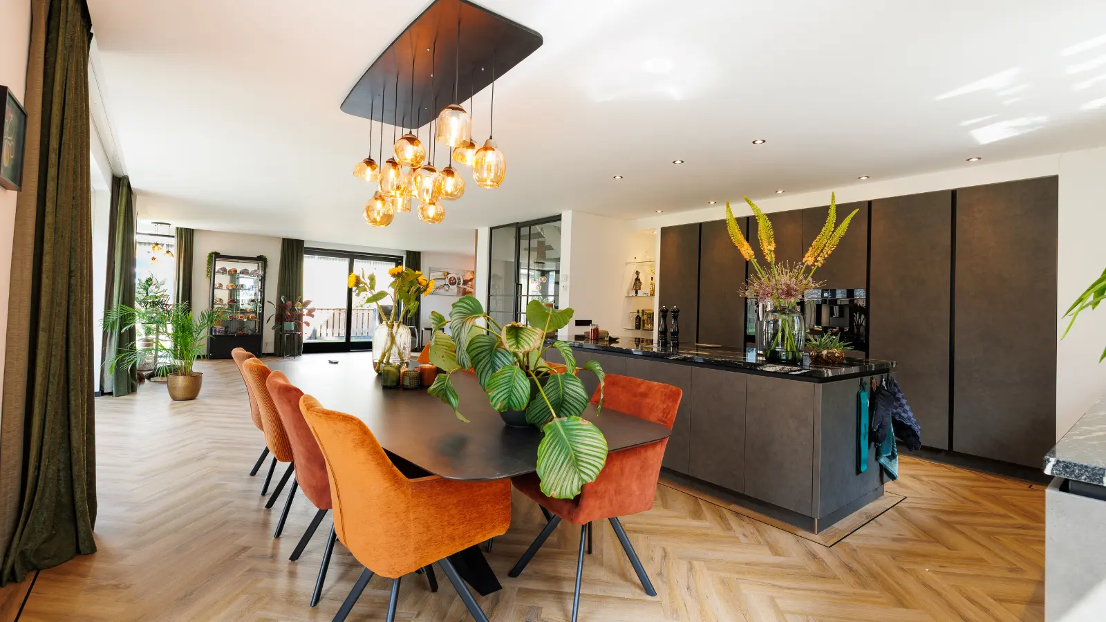 Grote open keuken met keukeneiland en eettafel met oranje stoelen