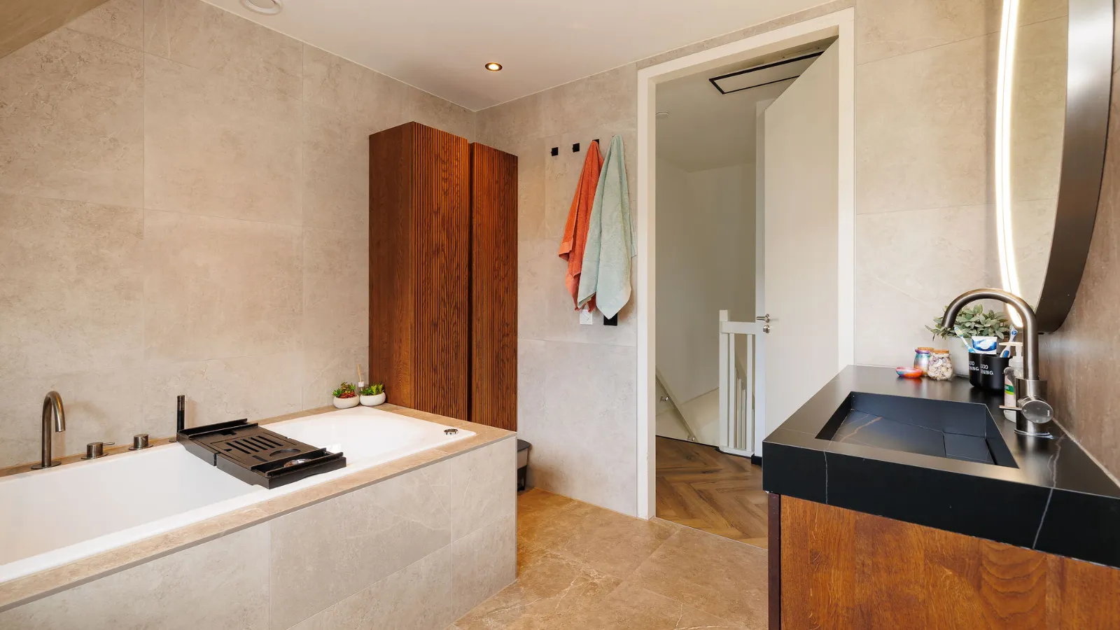 Badkamer met ligbad en bruine kast