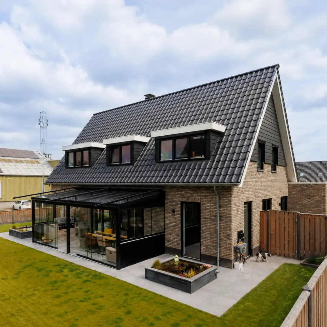 Vrijstaande woning met drie dakkapellen en een glazen veranda