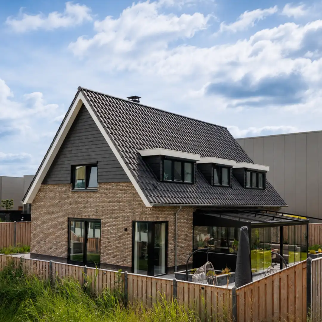 Vrijstaande woning met drie dakkapellen en een glazen veranda