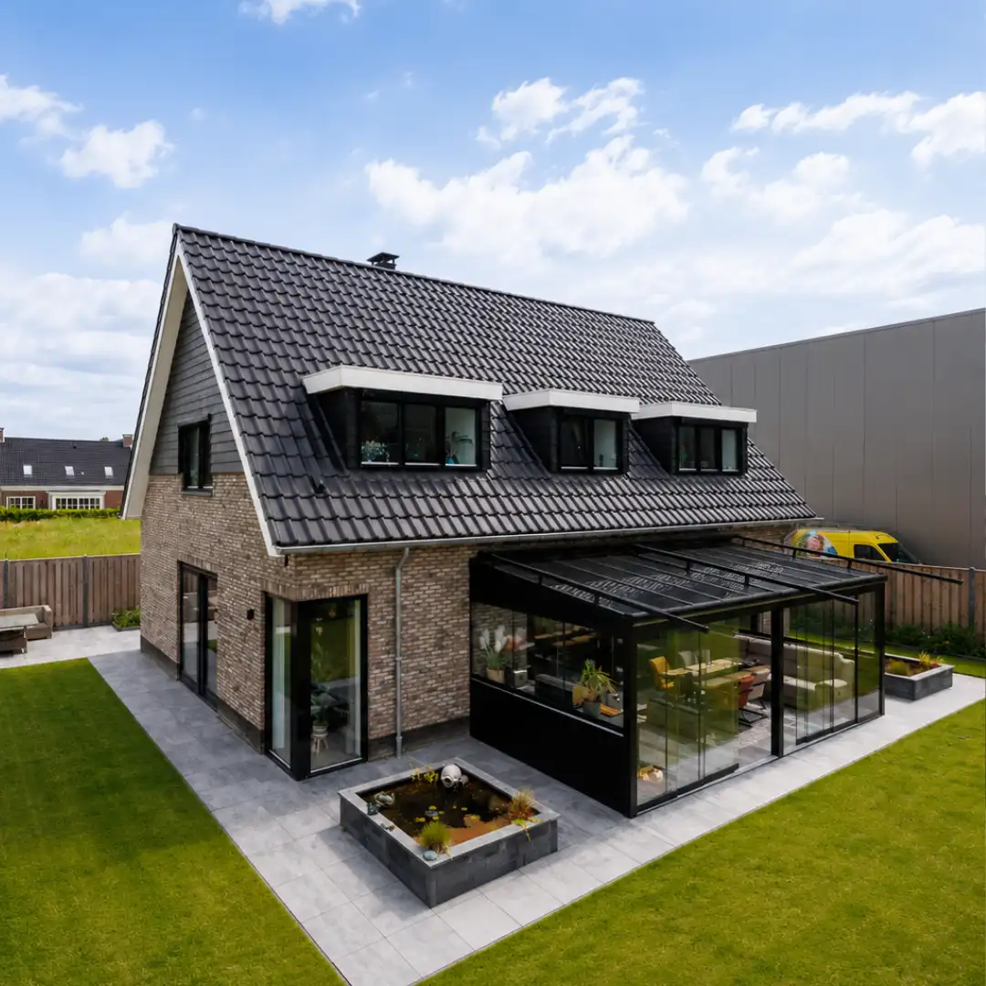 Vrijstaande woning met drie dakkapellen en een glazen veranda