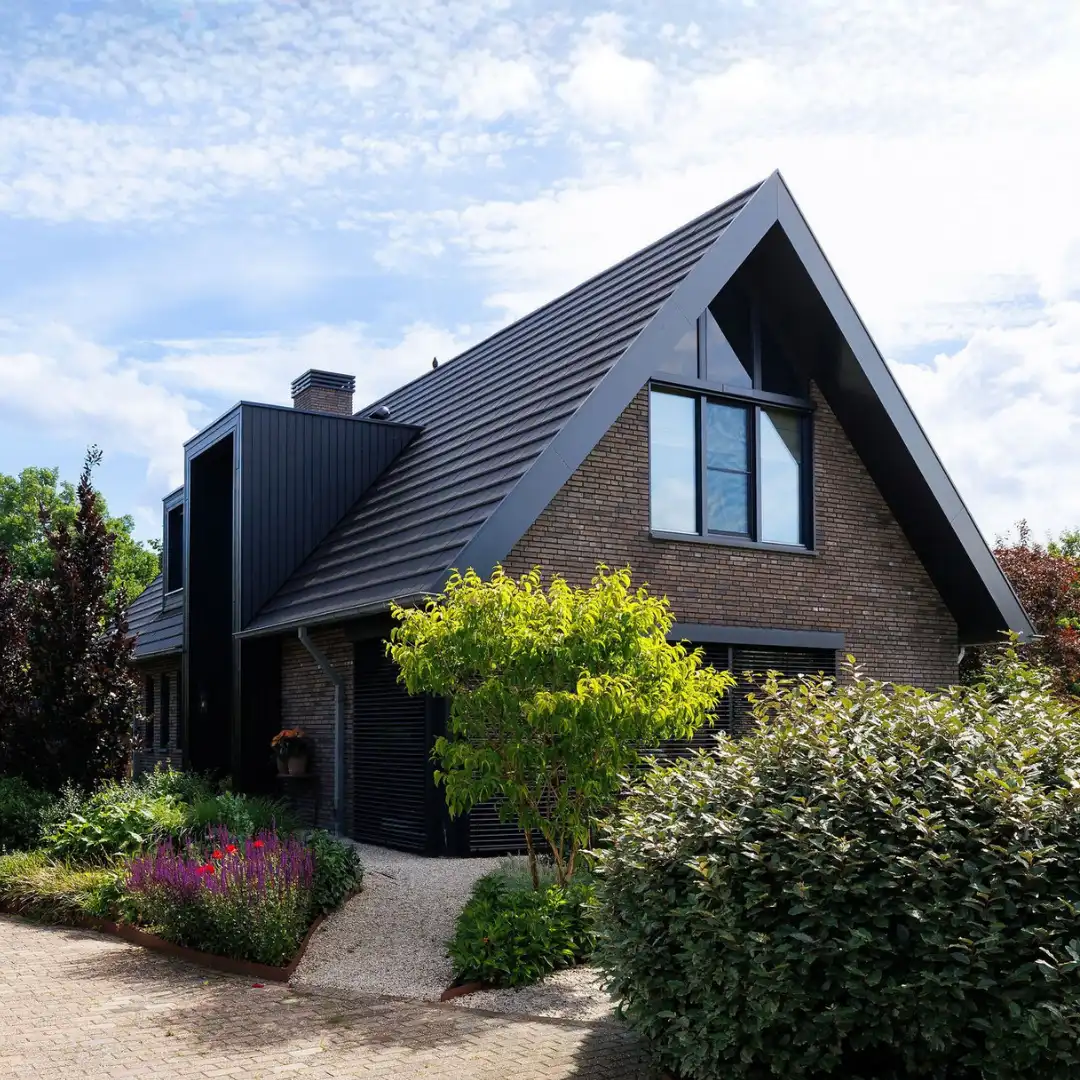 Vrijstaande schuurwoning met donkere gevelstenen, houten gevelbekleding en risaliet