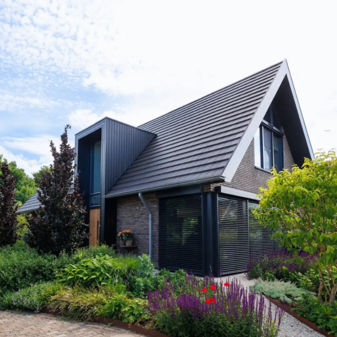 Vrijstaande schuurwoning met donkere gevelstenen, houten gevelbekleding en risaliet