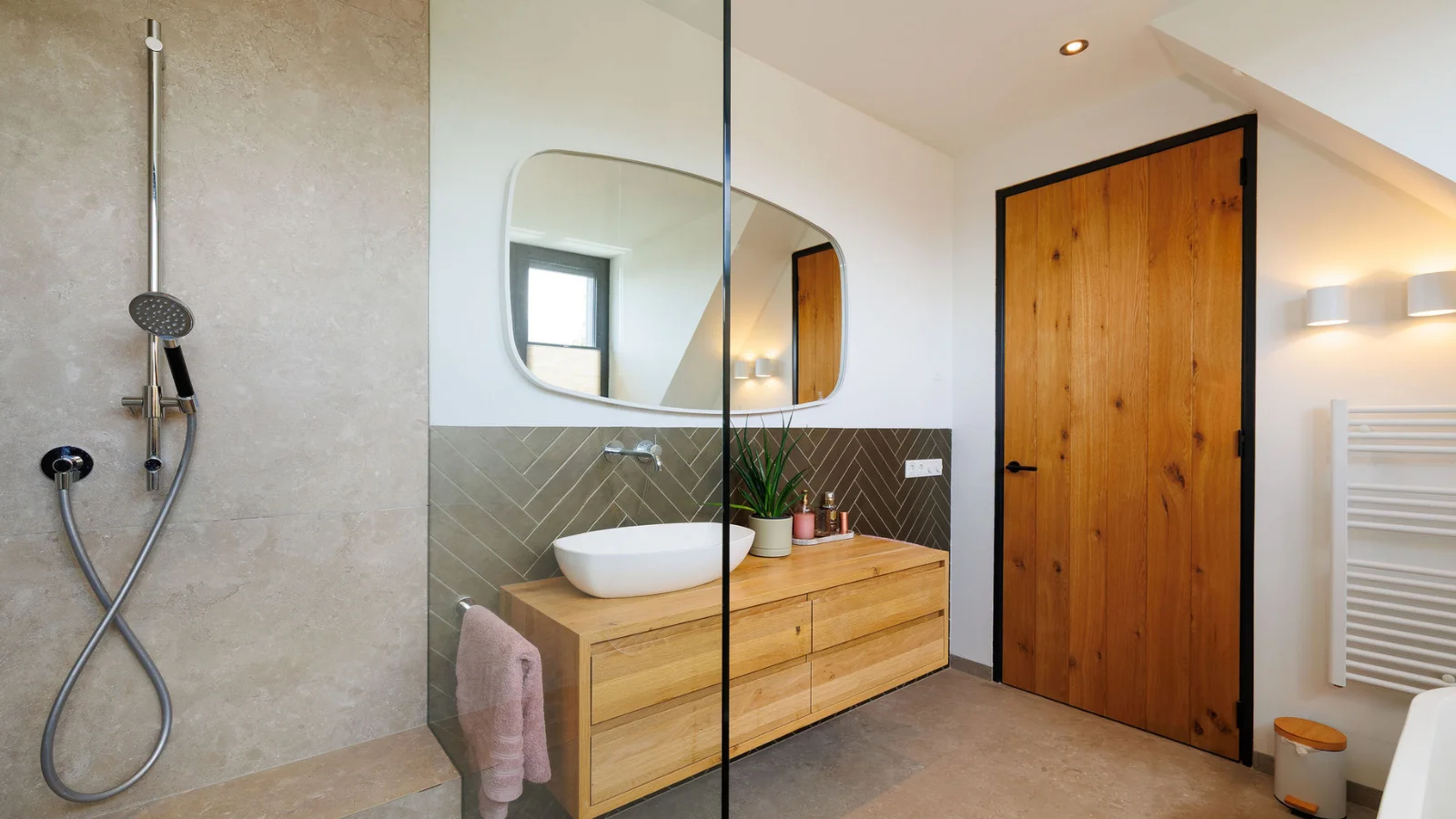 Badkamer met douche en houten deur