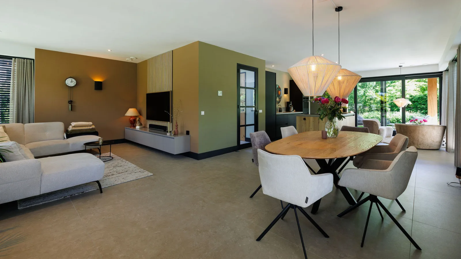 Open leefruimte met bank en eettafel met stoelen