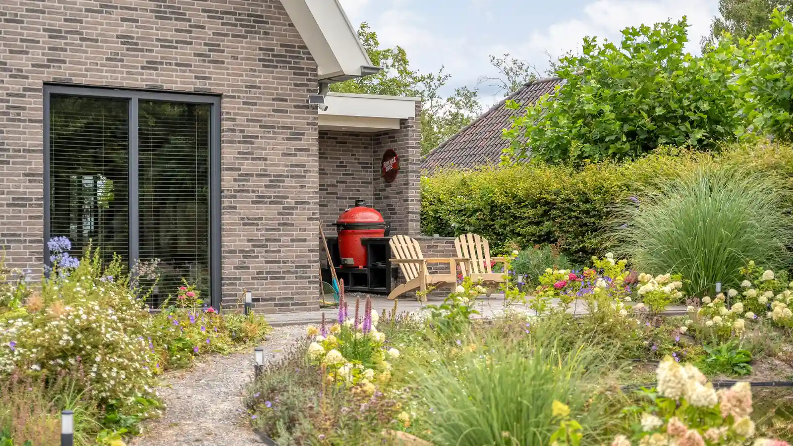 woning met grijze stenen en groot kozijn grenzend aan de tuin