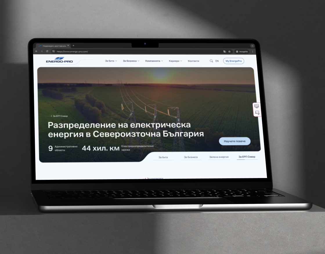 Laptop displaying the homepage of EnergoPro, featuring a banner with a landscape of power lines and fields, showcasing the text 'Разпределение на електрическа енергия в Североизточна България' (Electricity Distribution in Northeastern Bulgaria). The webpag