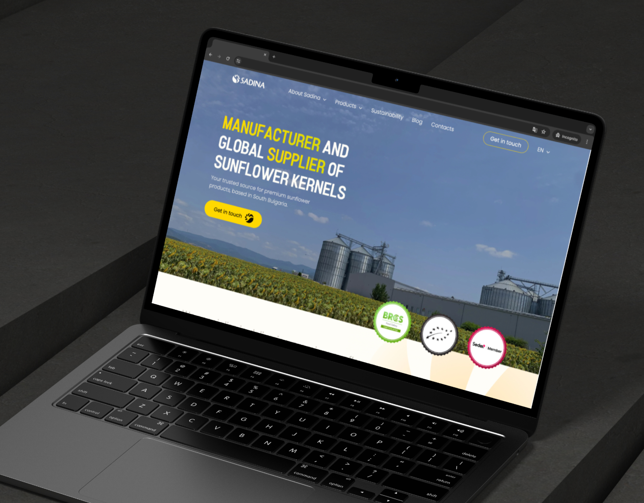 Sadina homepage on a laptop mockup, showing the sunflower field hero and certification badges