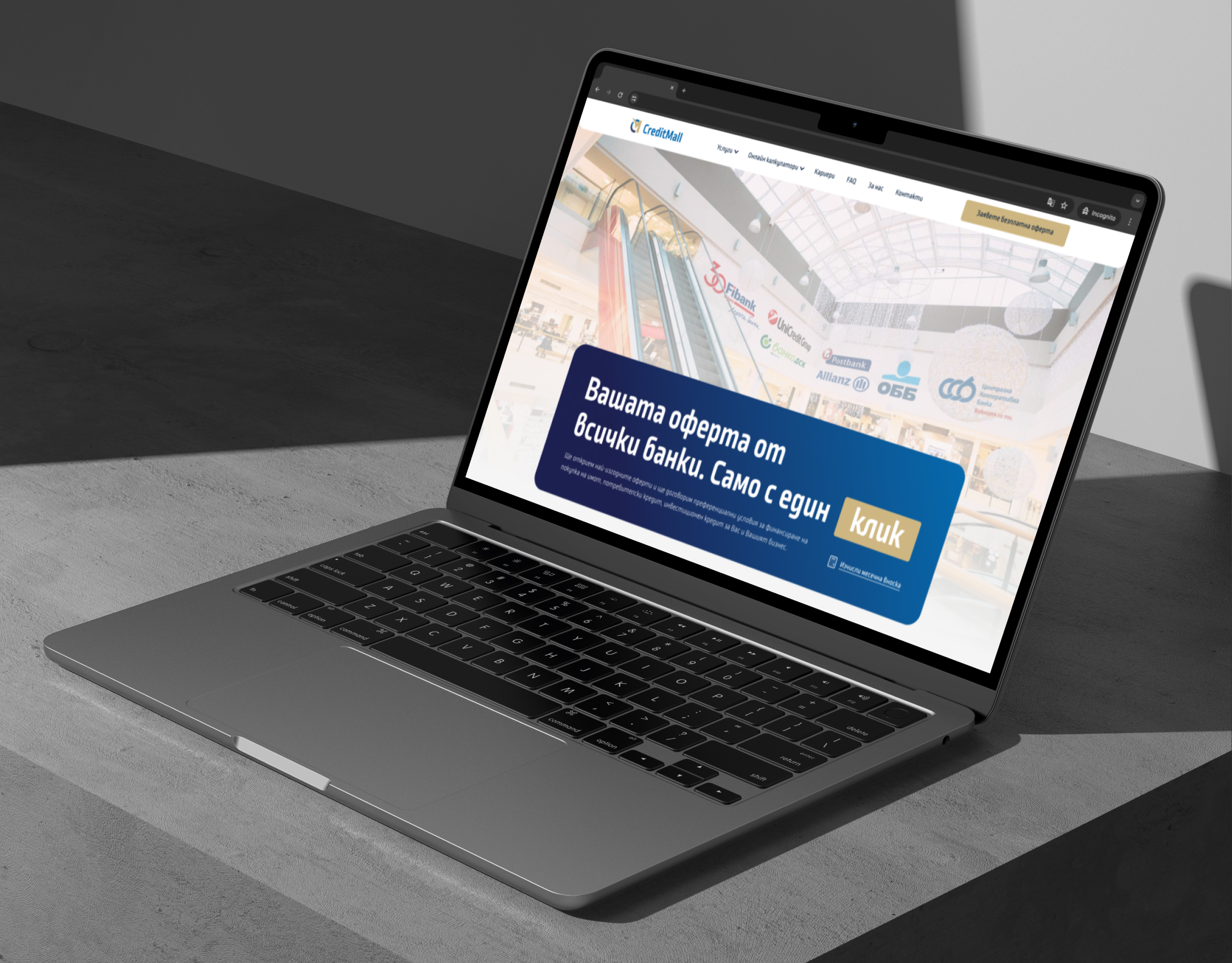 CreditMall homepage on a laptop angled on a grey concrete desk, showing the mall hero and navy headline banner