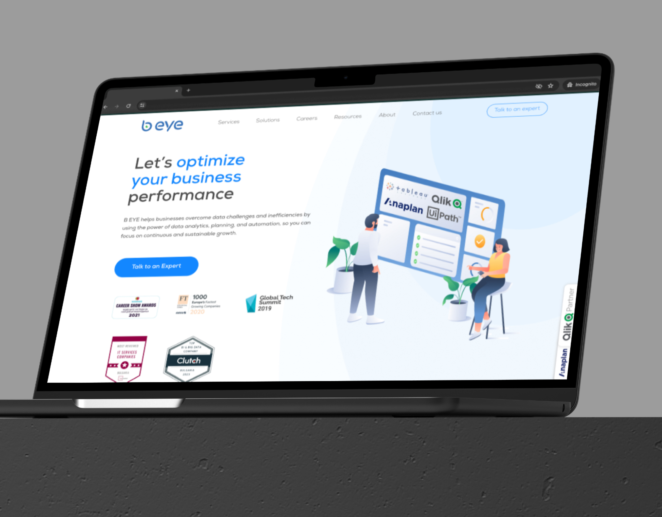 B-Eye homepage on a laptop against a grey backdrop, showing the optimise-your-business hero and award badges